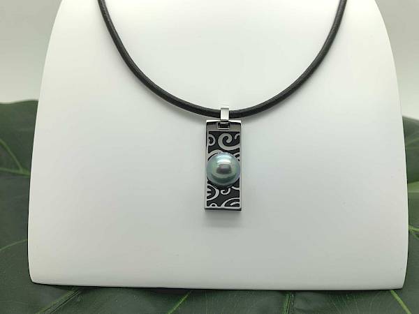 Collar de cuero con un colgante estampado y una perla azul